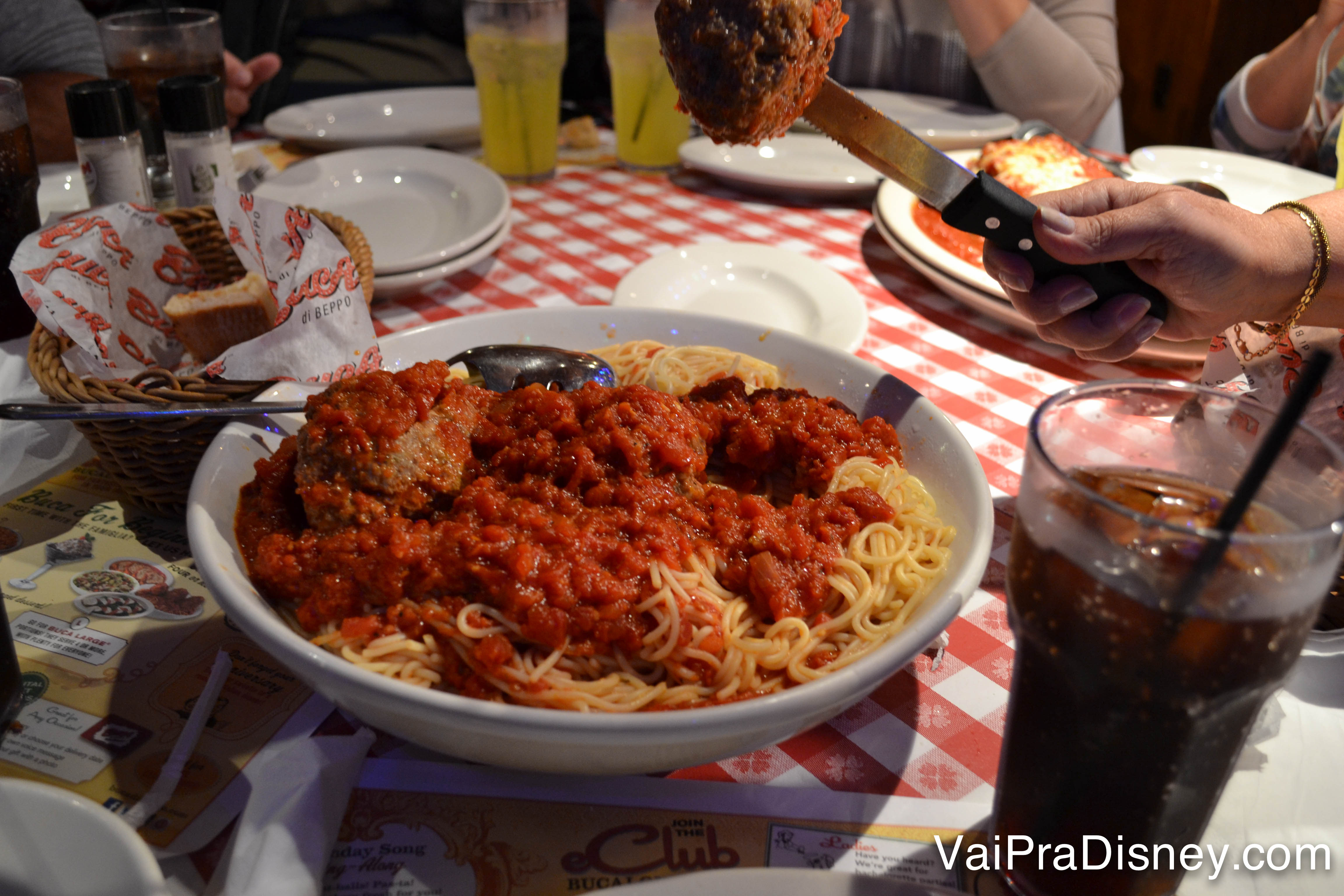 Prato de spaghetti enorme, para todo mundo se servir, com molho de tomate e almôndegas em cima 