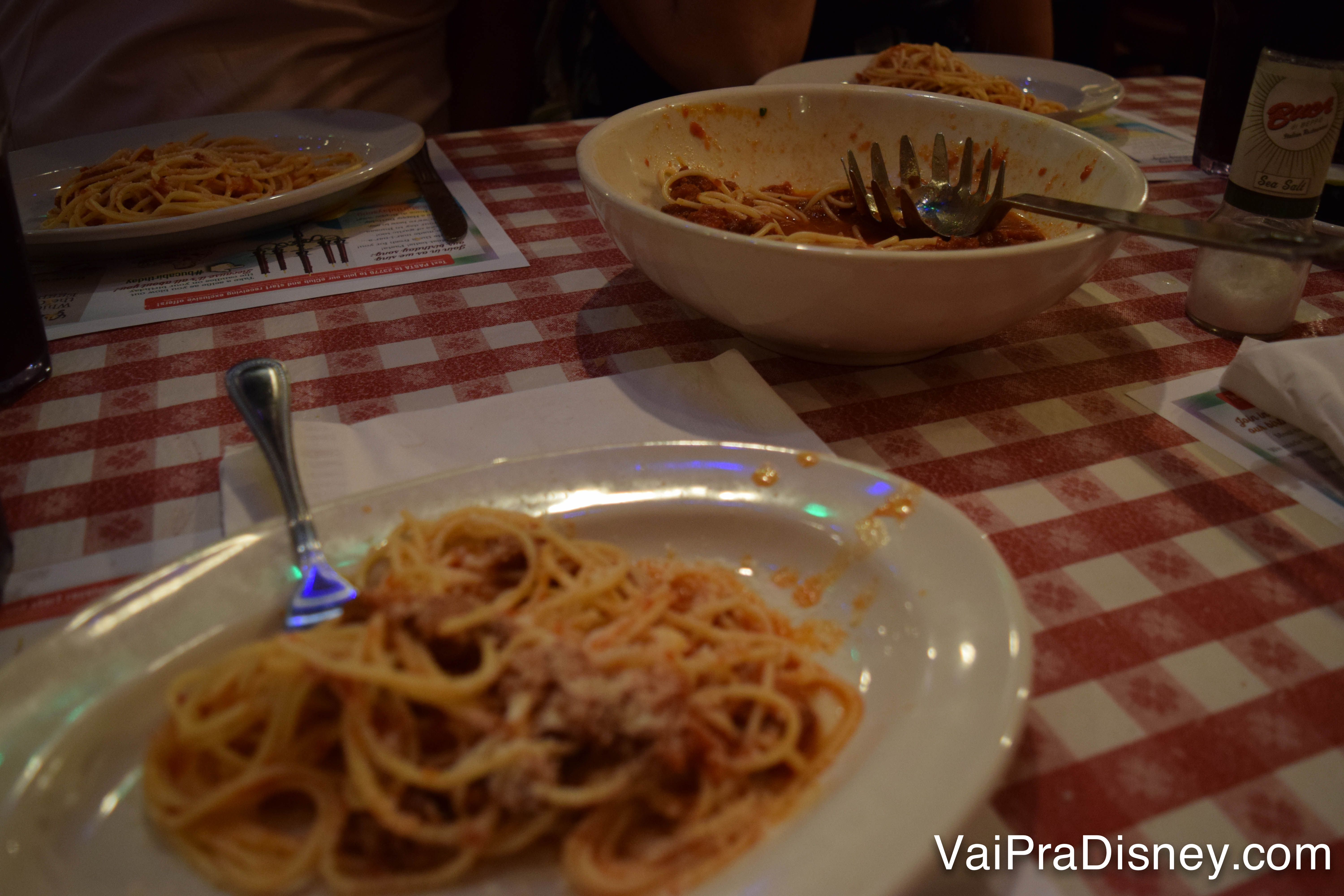 Foto do prato grande de spaghetti já quase vazio e um prato individual em primeiro plano, também com spaghetti 