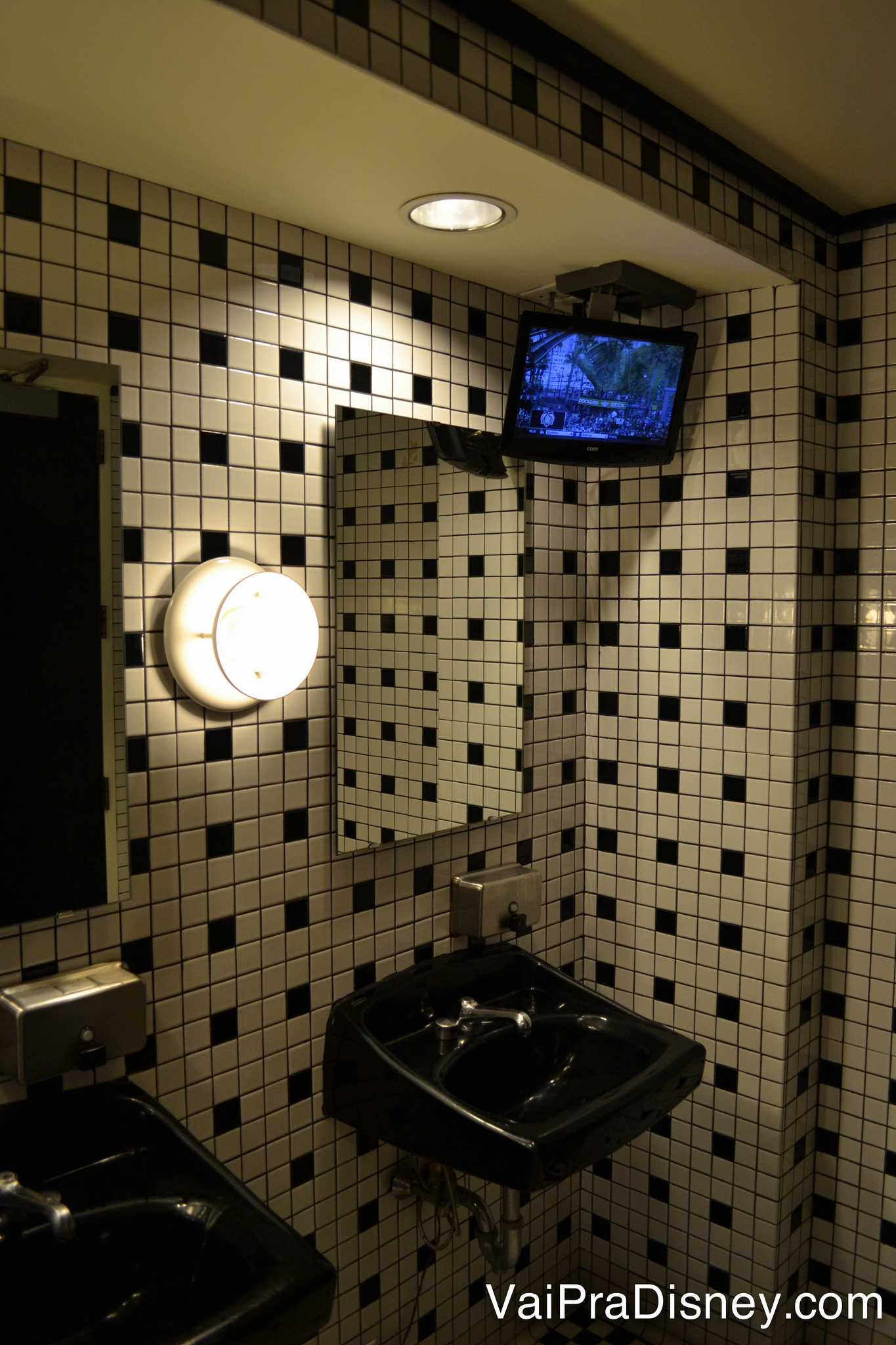 Pia no banheiro com uma TV, logo acima do espelho, no ESPN Club 