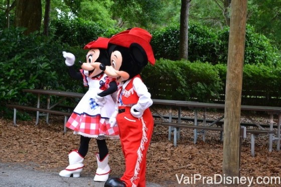 Durante intervalos ao longo do churrasco, os personagens param para tirar foto com os visitantes. Mickey e Minnie vestidos de cowboy acenando para alguém 