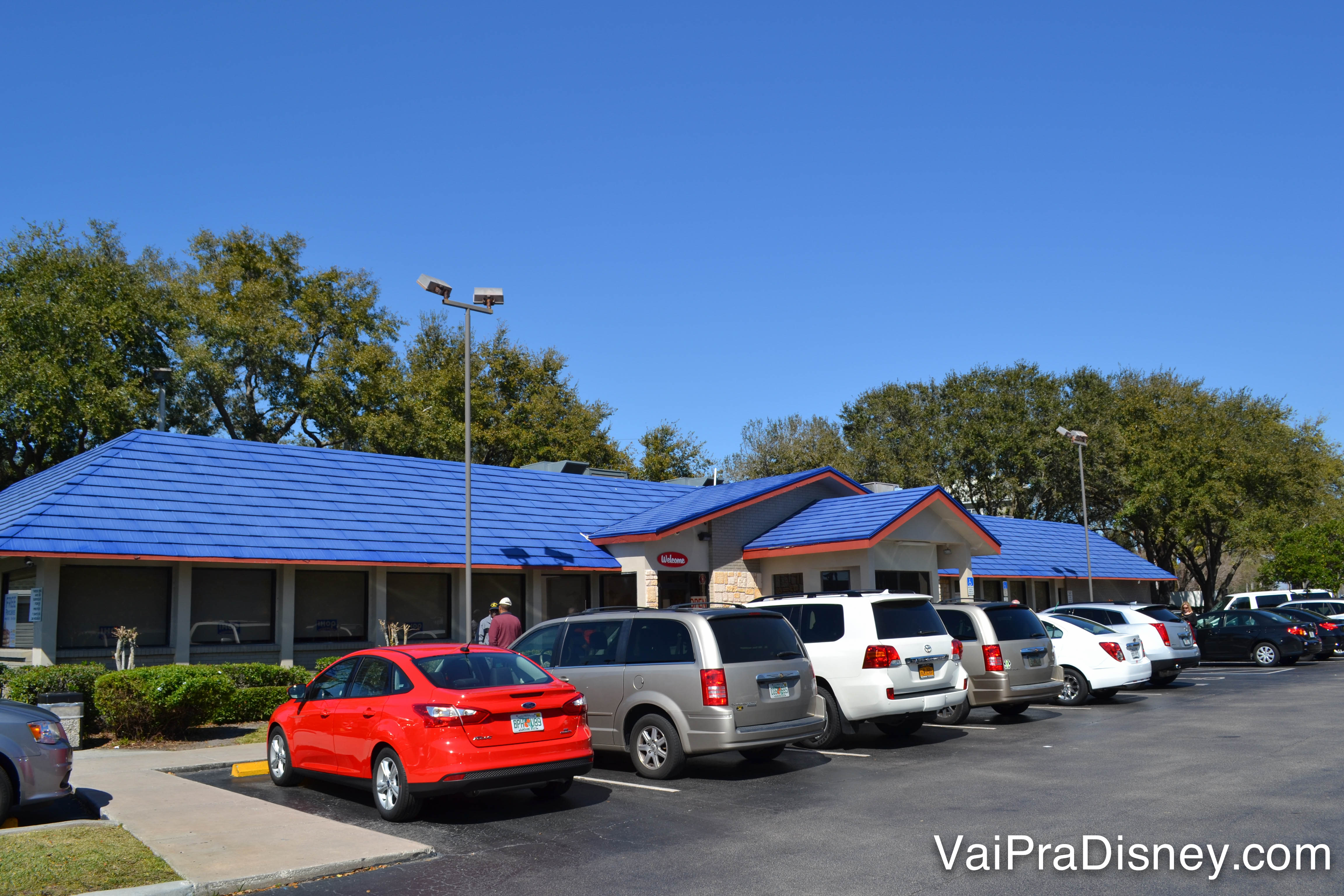 O estacionamento e o exterior do Ihop de Kissimee, com telhado pintado de azul 