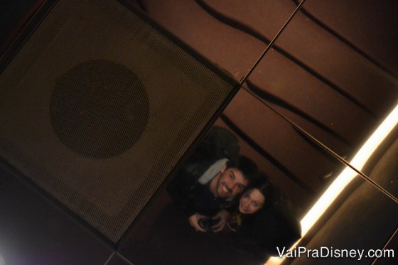 Foto da Renata e do Felipe refletidos em um teto espelhado na porta do restaurante.  