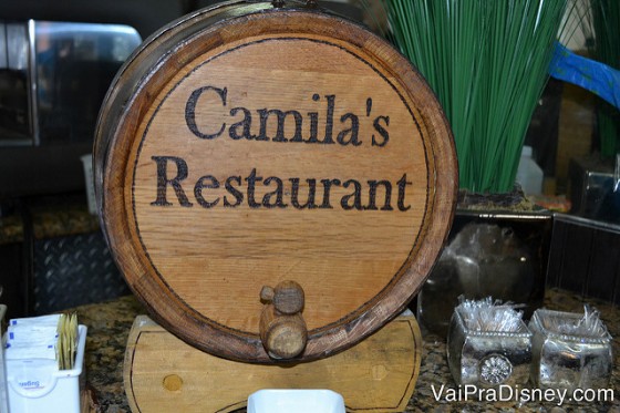 O barril de suco, feito de madeira e com "Camila's Restaurant" escrito 