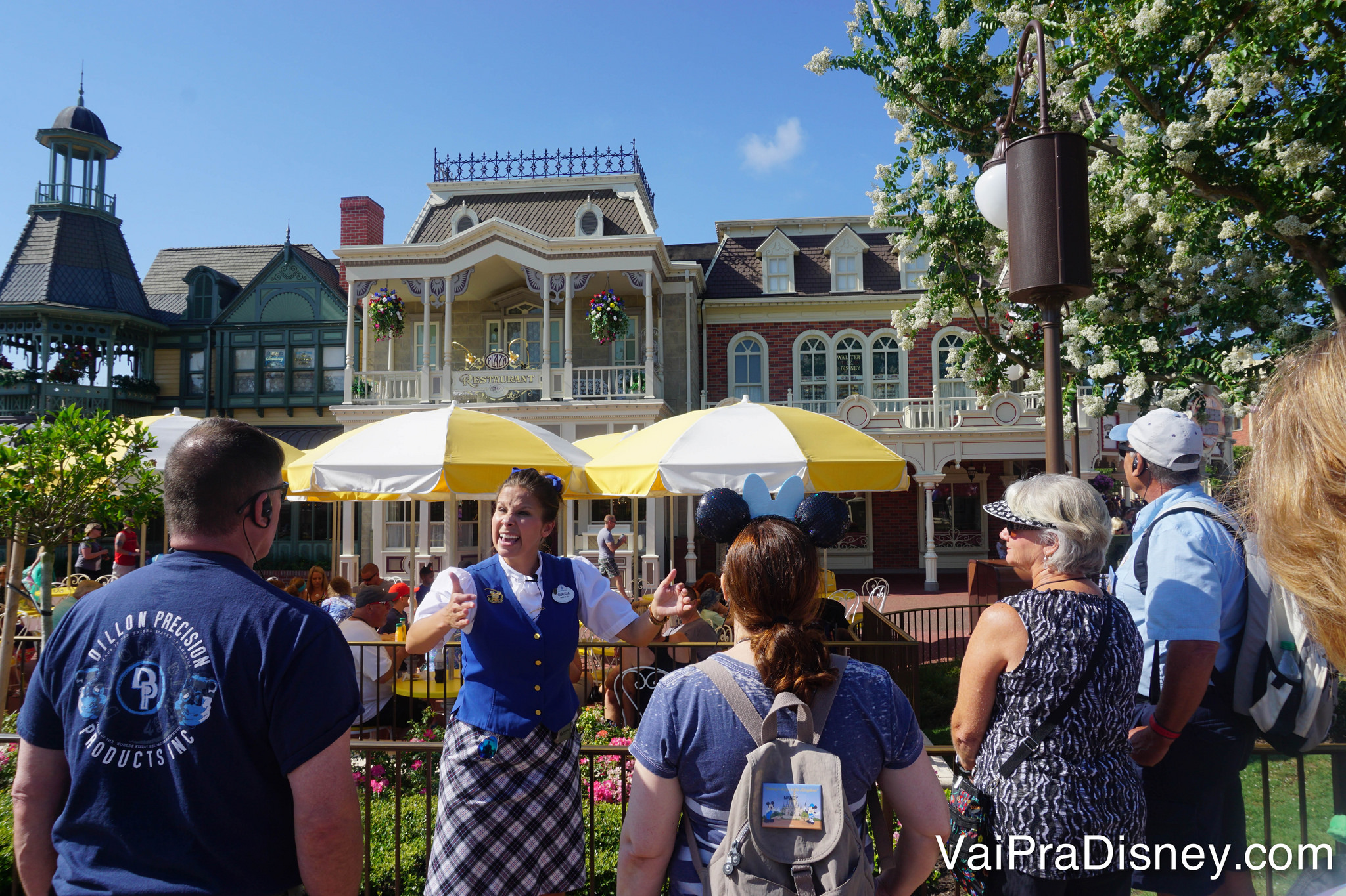 Foto da guia explicando algo para os visitantes na Main Street durante o Keys to the Kingdom 