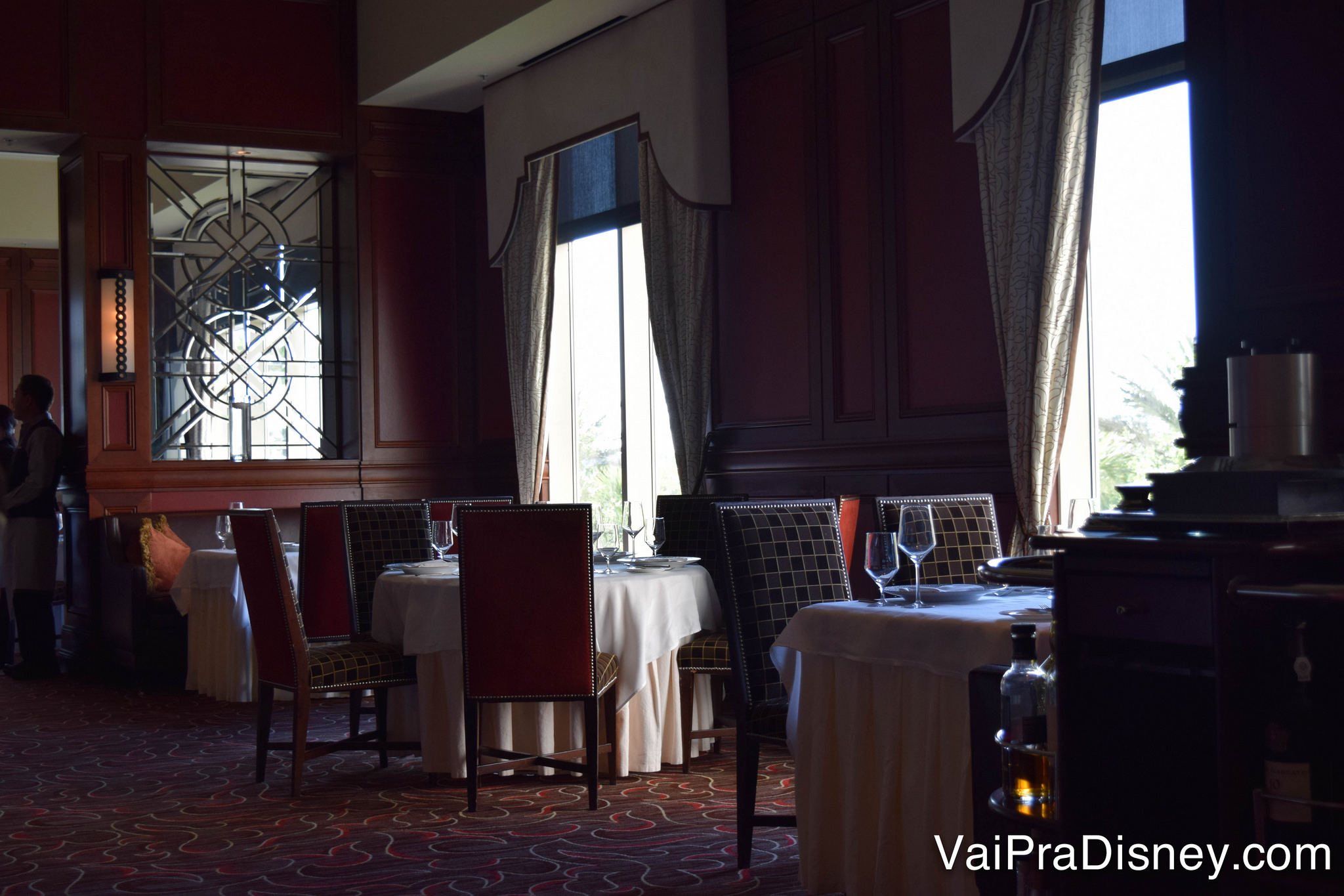 O ambiente elegante do restaurante, com cadeiras confortáveis e cortinas amplas 