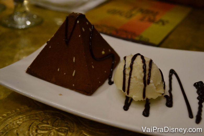 Foto da sobremesa, uma pirâmide de chocolate com sorvete ao lado 