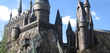 Foto do castelo de Hogwarts em Hogsmeade, no Islands of Adventure de Orlando, com o céu bem azul ao fundo.