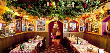 Foto de um dos salões do Buca di Beppo em Orlando, com decoração bem típica italiana e muitas plantas