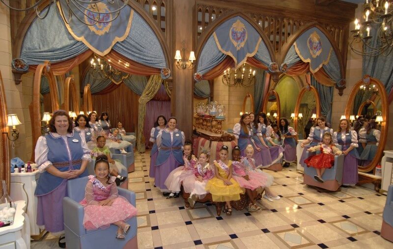 Bibbidi Bobbidi Boutique e diversas das mini princesinhas transformadas. Sonho de quase qualquer menina pequena, né? Foto de várias meninas vestidas de princesa, em companhia das fadas madrinhas no Bibbidi Bobbidi. 