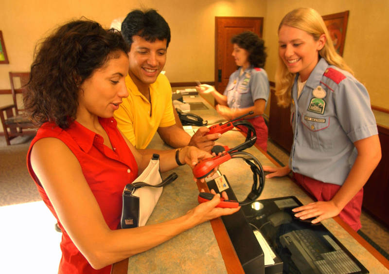 Pessoas retirando fones de tradução do inglês no Guest Relations