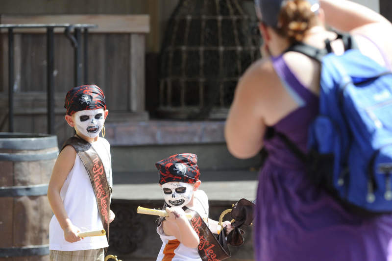 Vestidos de piratas, as crianças entram no papel durante todo o dia de parque! Foto de duas crianças vestidas de pirata no The Pirates League, com uma pessoa tirando foto deles 