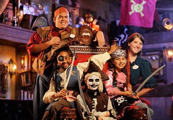 Foto de diversas crianças vestidas de pirata no The Pirates League ao lado dos funcionários da Disney. 