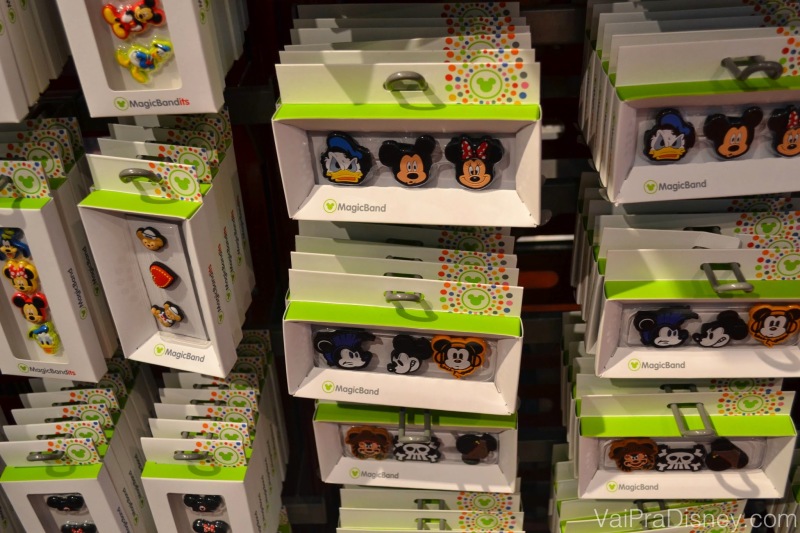 Acessórios para quem quiser enfeitar a sua MagicBand. Foto dos acessórios para colocar na MagicBand que são as carinhas de personagens como Mickey, Minnie e Donald, à venda em uma loja 
