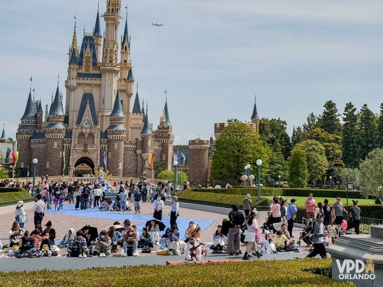 Castelo da Cinderela da Tokyo Disneyland de dia, com várias pessoas ao rdor.
