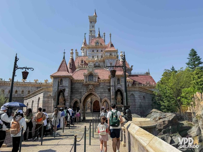 Fundos do castelo, com uma fila de turistas aguardando. 