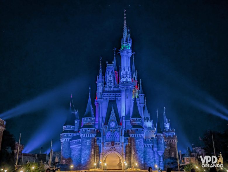 Castelo da Cinderela da Tokyo Disneyland à noite, iluminado em azul. 