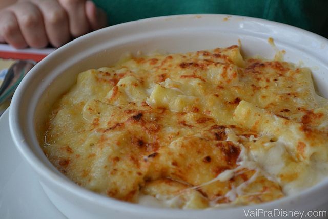 Imagem de um prato com uma massa coberta com molho branco e queijo gruyère gratinado. 