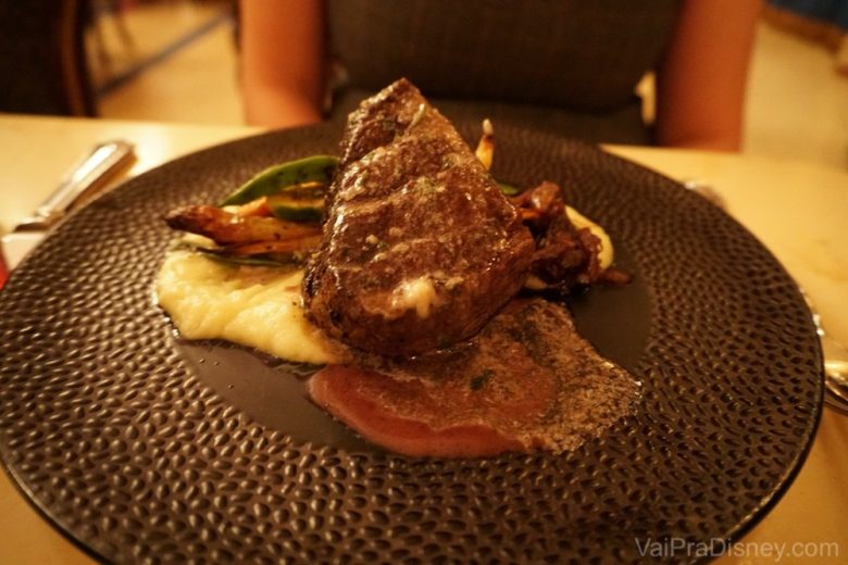 Foto do prato no Be our Guest com um filet mignon em cima de um purê de batata 