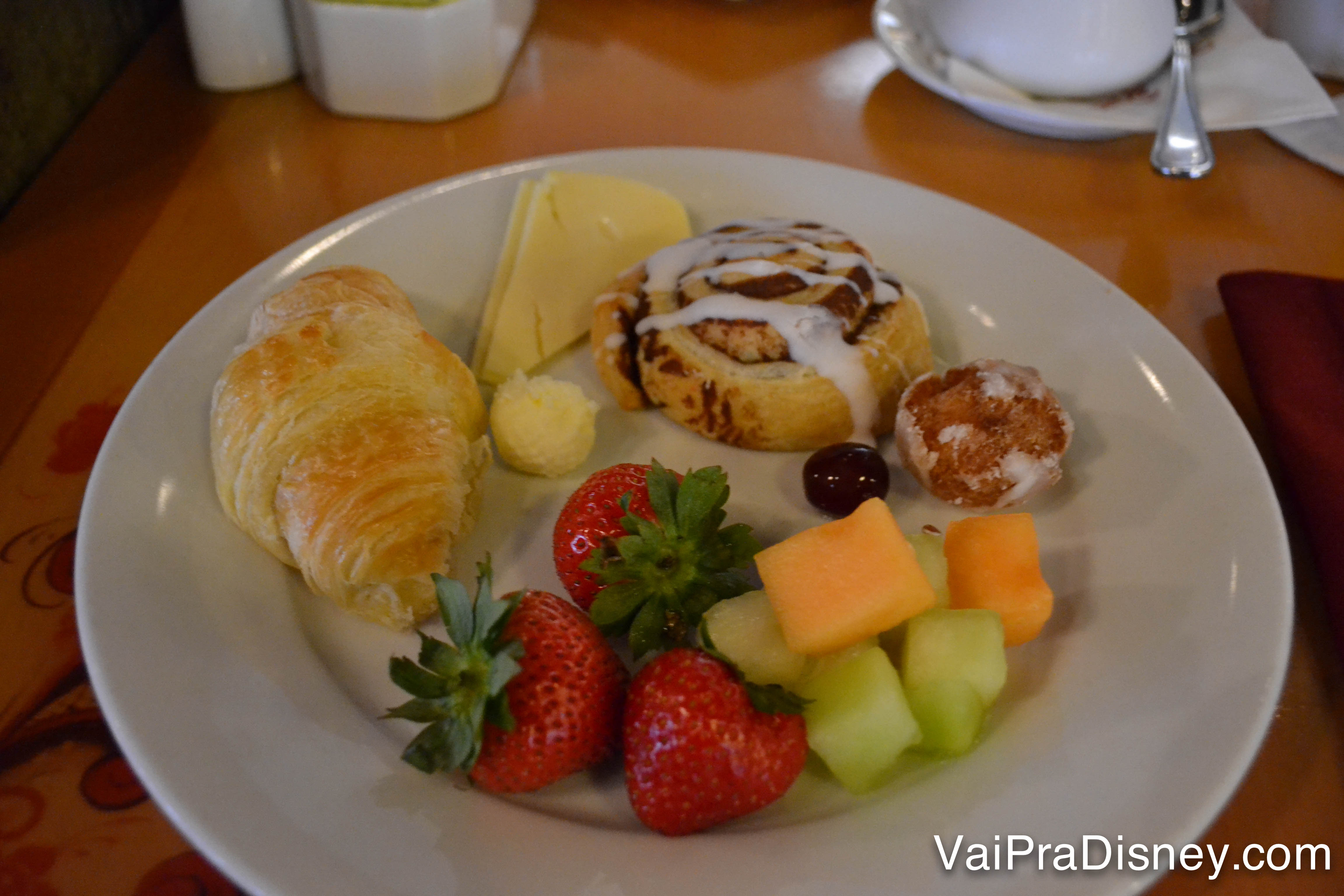 Foto do prato da Renata no café da manhã no Akershus, com croissant, pão doce, queijo e frutas