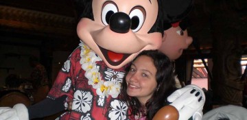 Foto da Renata com o Mickey havaiano (de camisa florida e colar) no Ohana