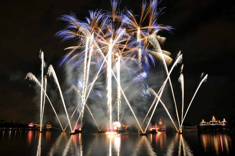 Illuminations em edição especial para o Ano Novo. Foto: divulgação Disney. Foto do show de fogos de Ano Novo do Epcot, com os fogos estourando acima da superfície do lago. 