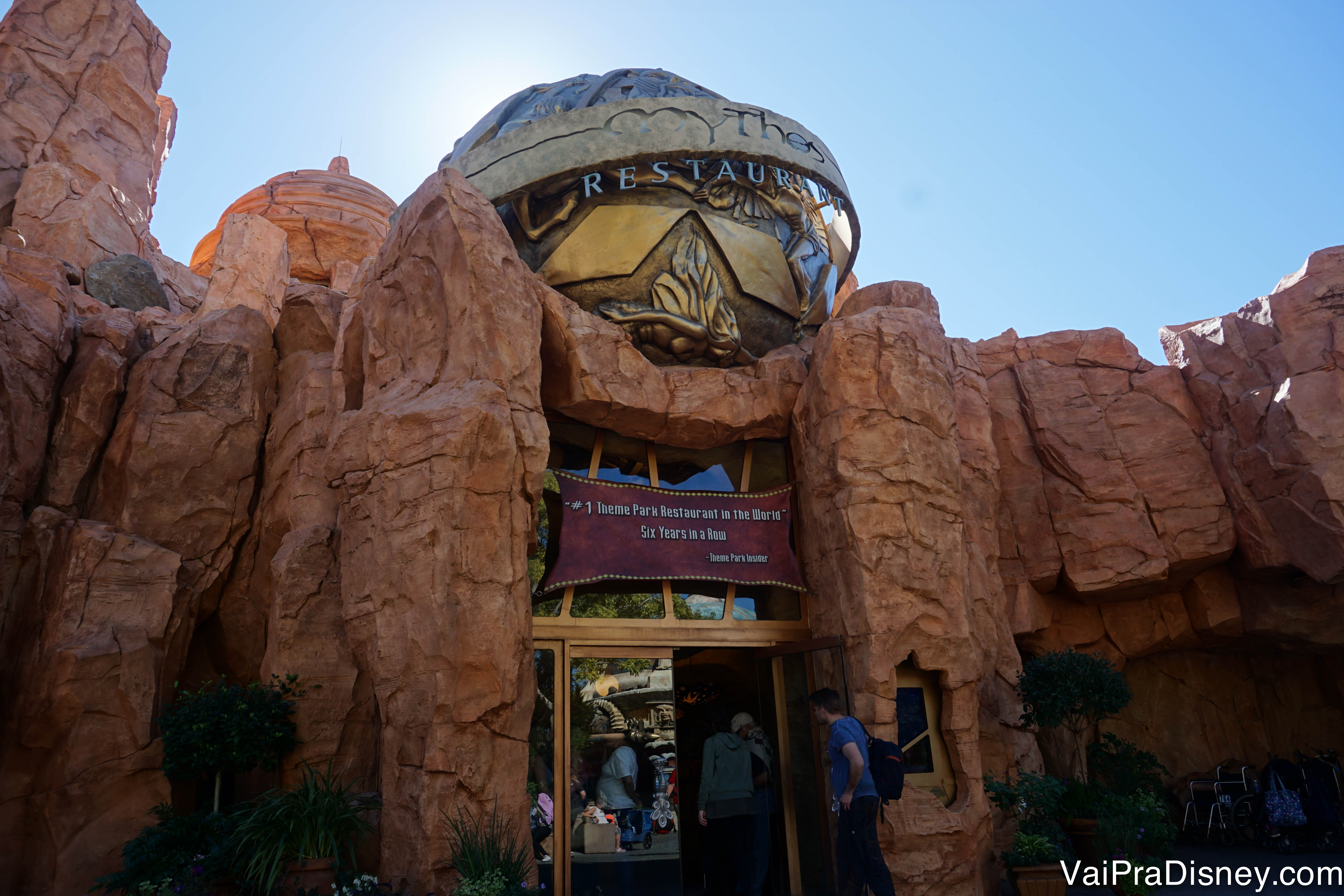 Foto do exterior do Mythos, que imita uma caverna e tem uma fonte grega no título  