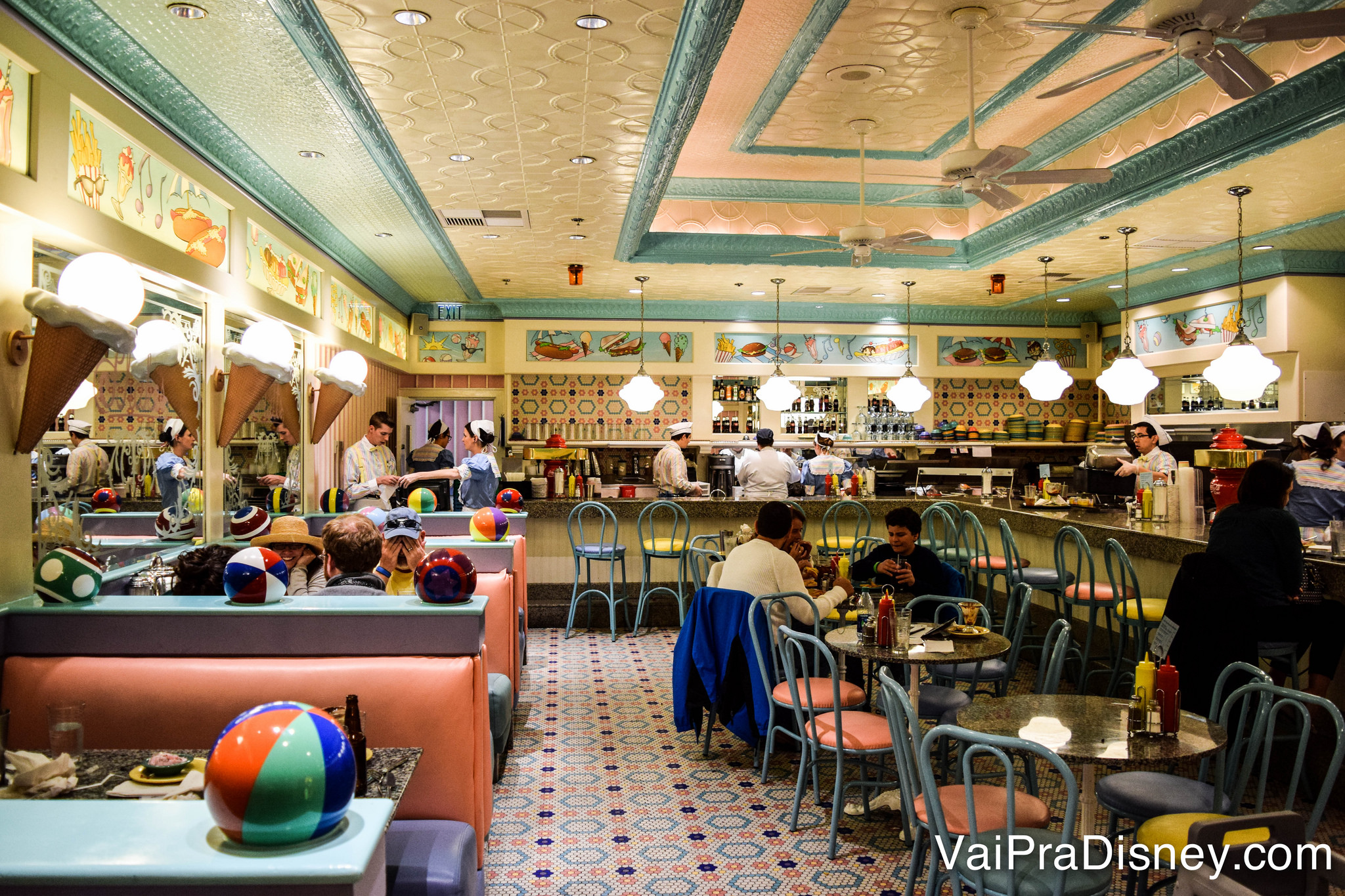 Foto do interior da lanchonete Beaches and Cream, com tema vintage e decoração em rosa, amarelo e azul, com alguns toques de praia 