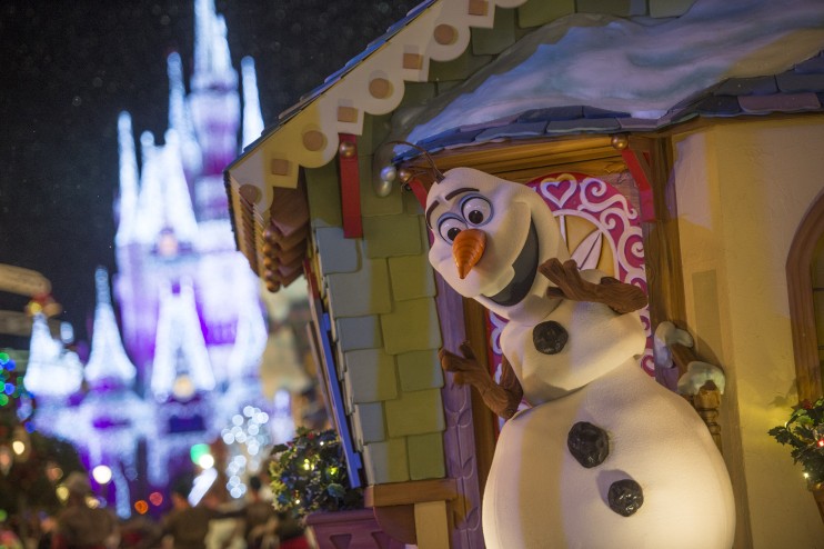 Não aguento a fofura do Olaf na parada de Natal, gente! Foto do Olaf durante a parada de Natal do Magic Kingdom, com o castelo da Cinderela iluminado ao fundo. 