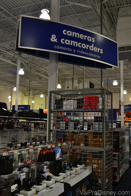 Foto da área de câmeras fotográficas e filmadoras da Best Buy. Há uma placa que diz "Cameras & Camcorders" 