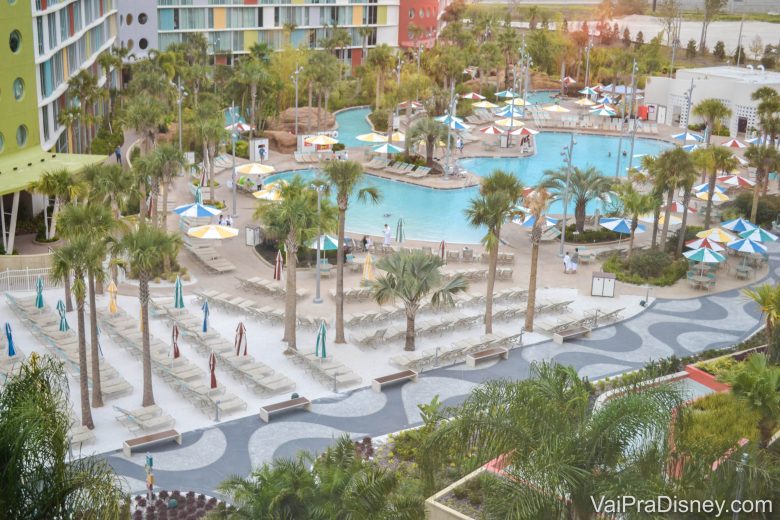 Foto de uma das piscinas do Cabana Bay, vista de cima, bem grande e rodeada de palmeiras 