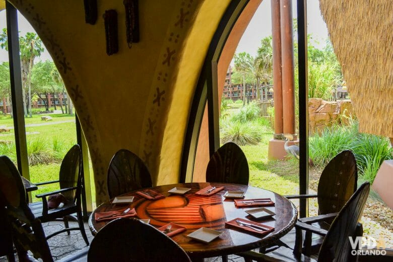 Sanaa tem uma vista privilegiada para os animais no Animal Kingdom Lodge. Foto do Sanaa, com a mesa ao lado da janela que tem vista para a savana. 