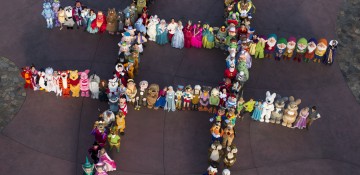 Foto de muitos personagens da Disney reunidos, organizados e formando uma letra H vista de cima, durante o Character Palooza, que acontece no Hollywood Studios