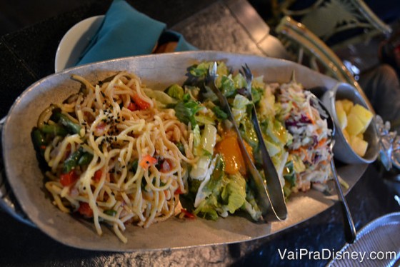 A salada que vem divida em 3 partes: mix de folhas com alguns gomos de tangerinas em conserva, uma salada de macarrão e uma salada de repolho. 