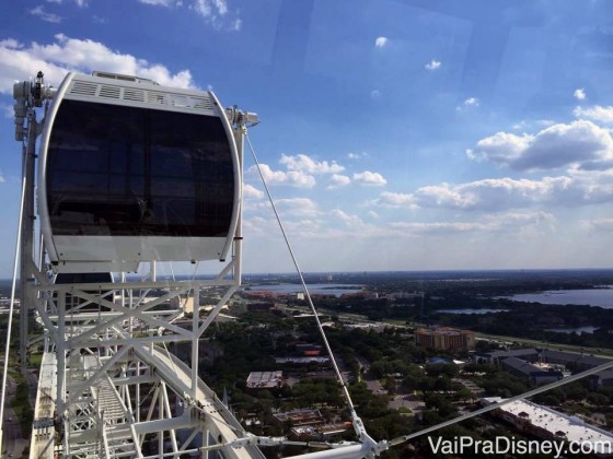 Um pouquinho da vista da cidade da The Wheel. Foto tirada de uma cápsula da The Wheel, mostrando a cápsula ao lado e a vista da cidade com o céu azul ao fundo 