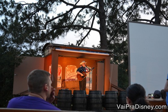 Foto do cantor no palco com o violão durante a parte das cantigas do Campfire