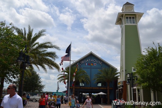 Foto do exterior do restaurante The Boathouse, em Disney Springs, que como o nome diz, imita uma casa de barcos, com um farol ao seu lado 