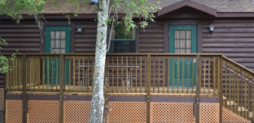 Foto do exterior da cabine no Fort Wilderness, de madeira e com a porta pintada de verde-escuro.