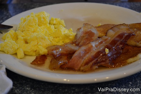 Foto do prato com panqueca, ovos e bacon: típico café americano. 