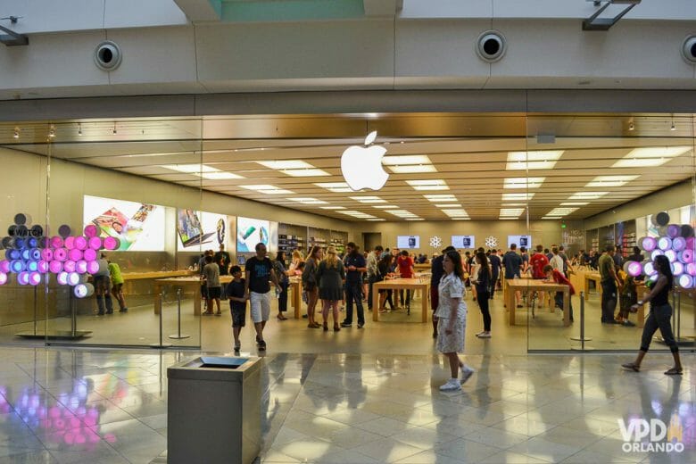 Apple, uma das principais lojas para gastar os seus dólares! Foto da loja da Apple em Orlando, cheia de visitantes entrando, saindo e dentro. 