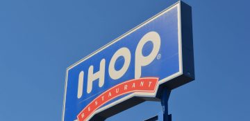 Foto da placa do Ihop de Orlando, com fundo azul e letras brancas, e o céu também azul ao fundo