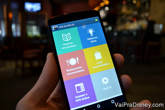 Foto de uma mão segurando um celular com o app VPD de Bolso aberto na tela inicial. 