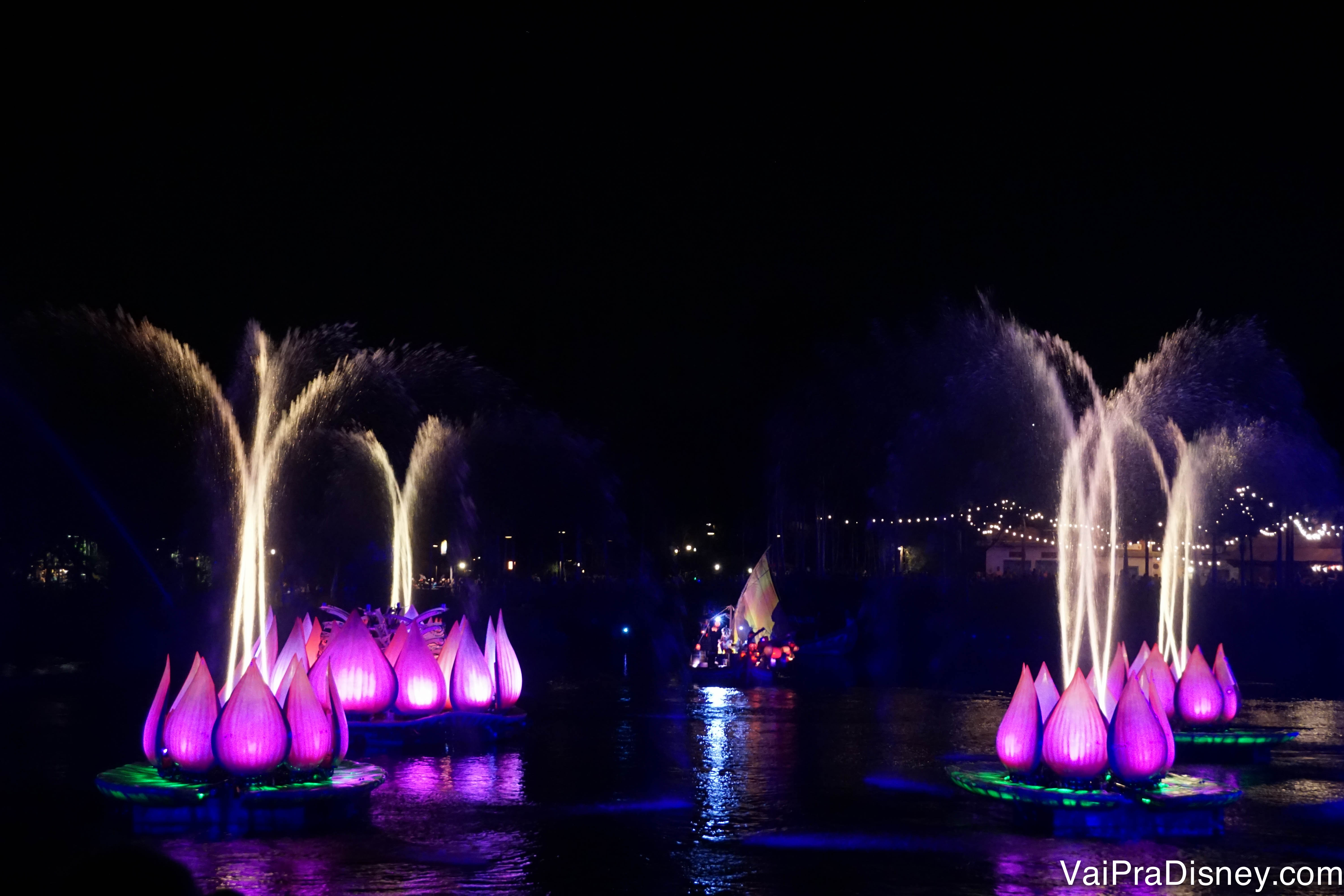 Foto do show noturno do Animal Kingdom, o Rivers of Light. Há vitórias-régia gigantes e cor-de-rosa no lago, com fogos saindo de dentro delas. 