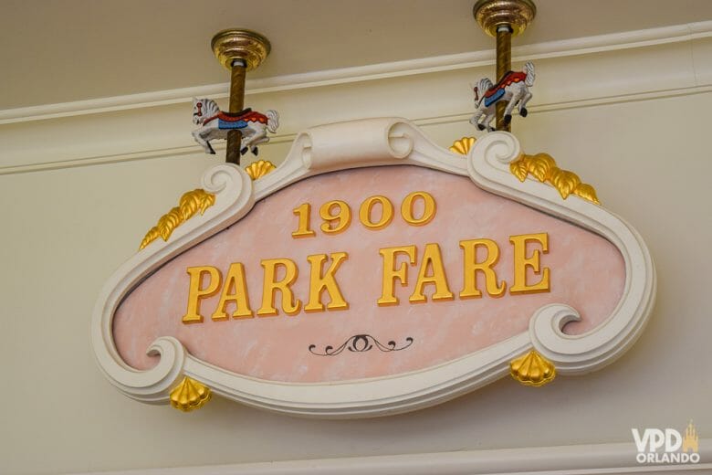 O café da manhã do 1900 Park Fare é um dos nossos preferidos da Disney! Foto da placa na entrada do restaurante 1900 Park Fare, com o fundo rosa claro e as letras em dourado 