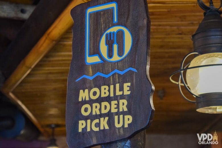 Foto de uma placa em um restaurante da Disney que diz "Mobile Order Pick-up"