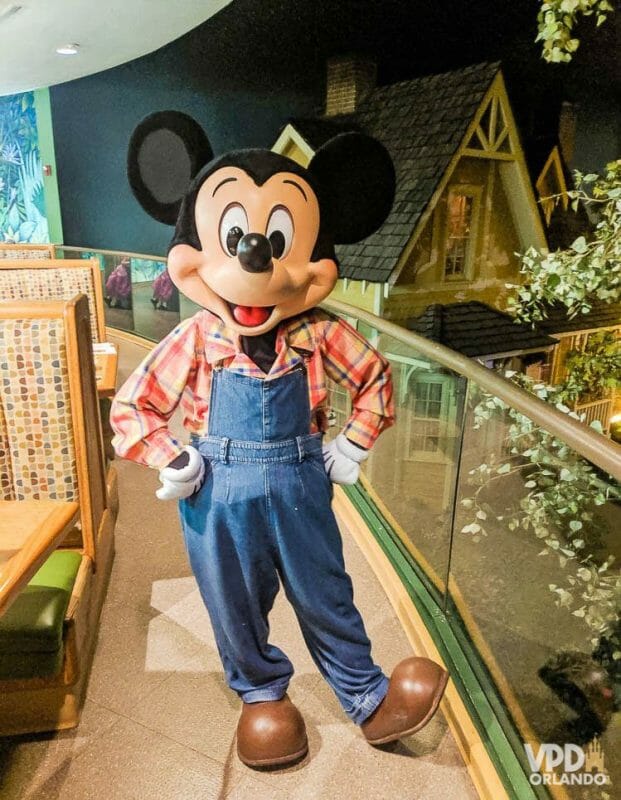 O Garden Grill no Epcot tem um almoço bem gostoso com o Mickey na versão fazendeiro! Fofo, né? Foto do Mickey no Garden Grill, no Epcot, com uma jardineira jeans, camisa xadrez e botas. 