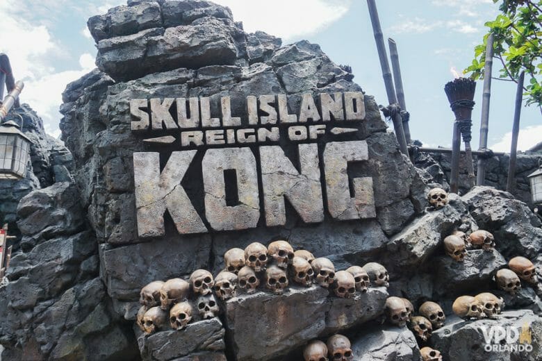Essa é uma das atrações mais recentes do parque. Foto da entrada da atração Skull Island: Reign of Kong no Islands of Adventure, com diversas caveiras e o título escrito em uma pedra. 