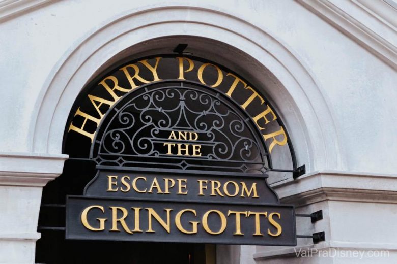 A atração que eu mais amo na área de Harry Potter. Foto da placa na entrada da atração do Beco Diagonal, a Harry Potter and the Escape from Gringotts. A placa é em preto e dourado. 