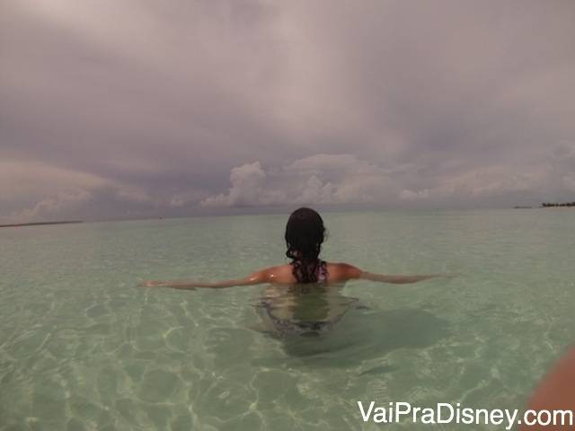 Foto da Renata de costas no mar transparente em Serenity Bay, a praia só para adultos nas Bahamas 