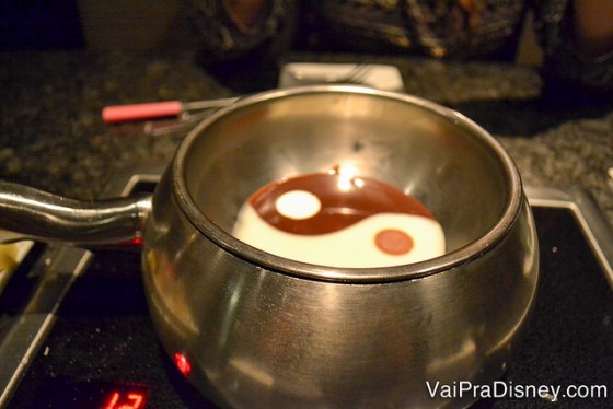 Foto de uma panelinha com fondue de chocolate branco e preto formando um yin-yang 