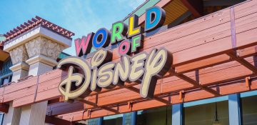 Foto da placa da loja World of Disney, que fica em Disney Springs e é a maior loja Disney do mundo. A placa tem letras coloridas.